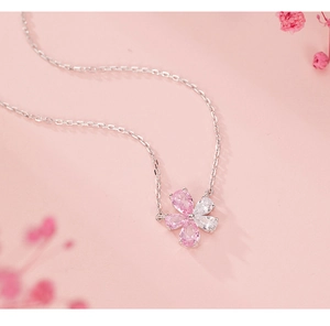Macro shot of pink and clear zircon flower pendant with a delicate silver chain