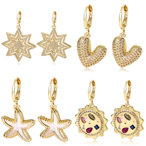 Macro view of gold shell and starfish earrings with cubic zirconia and colorful enamel