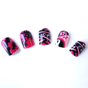 Pink and black Halloween press-on nails with spider web and mummy eye patterns