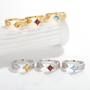 Detail of square-cut colorful gemstones on S925 sterling silver rings set on stone pillars