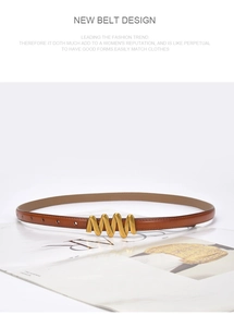 Close-up of a brown leather belt with a golden wavy buckle on a fashion magazine
