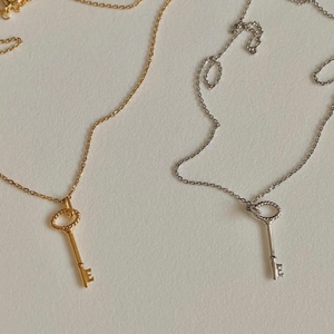 Detail of vintage key pendants on delicate gold and silver minimalist chains
