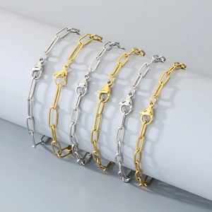 Close-up of gold and silver paperclip chain necklaces with lobster clasps on a white stand