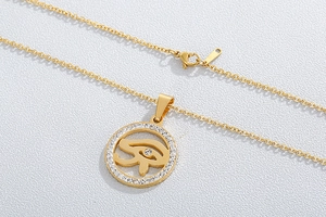 Detailed close-up of golden Eye of Horus pendant with sparkling rhinestone pavé border