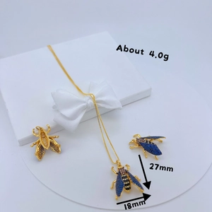 Golden bee necklace and earrings set with blue zircon crystals in a gift box