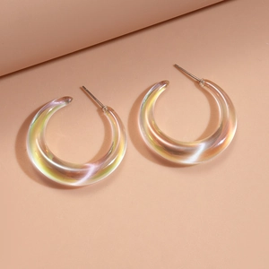 Detailed view of iridescent C-shaped acrylic earrings with transparent rainbow finish