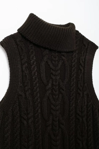 Detail of high turtleneck and chunky cable knit texture on a dark brown sweater vest
