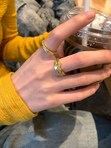 Detail of 18K gold plated feather ring with zircon stones worn on hand for daily styling
