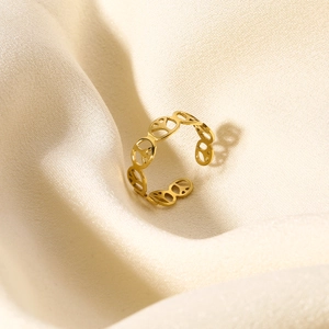 Macro detail of polished gold hollow peace sign pattern on stainless steel ring
