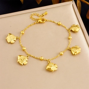 Detailed close-up of golden stainless steel ocean series bracelet with fish pendants