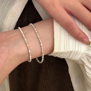 Detail of s925 sterling silver square crushed silver bracelets on woman wrist