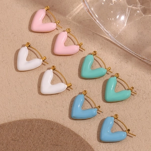 Detail view of heart-shaped enamel hoop earrings in pink, white, mint and sky blue colors