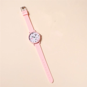 Angled view of pink silicone strap children watch with flamingo pattern on light background