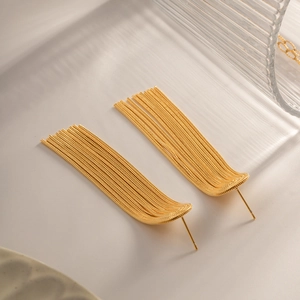 Detailed view of elegant gold long tassel earrings with multiple metal chains on a prop