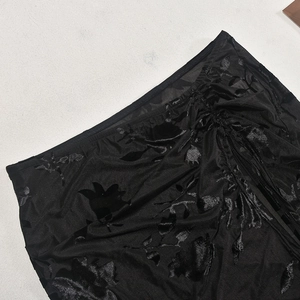 Detail of black mesh fabric with floral velvet flocking and adjustable drawstring ruching