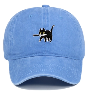 Close-up of black cat biting a knife embroidery on washed blue denim baseball cap