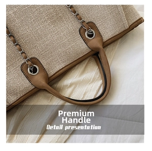 Detail presentation of khaki woven tote with brown leather handle and silver chain decoration
