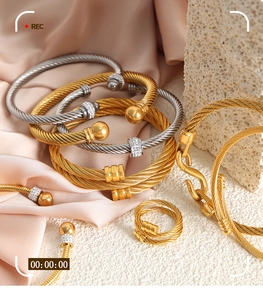 Detail of twisted cable gold and silver bangles with micro-pave zircons on silk background