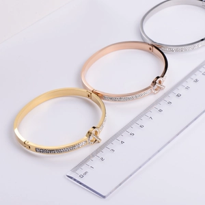 Set of minimalist stainless steel bangles in gold, rose gold, and silver with zircon accents