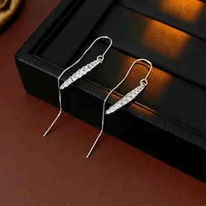 Dettaglio degli orecchini pendenti in argento con zirconi lucidi su scatola di gioielli nera