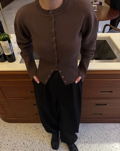 Close-up of a slim-fit dark brown knit cardigan with button details and crew neck