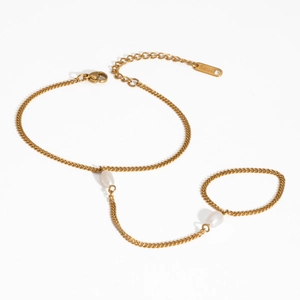 Détail d'un bracelet de doigt en acier inoxydable doré avec d'élégantes perles blanches