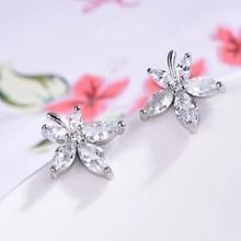 Detailed macro view of silver flower stud earrings with marquise-cut white zircons