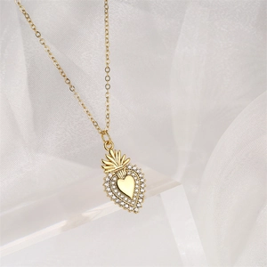 Vue détaillée d'un pendentif coeur doré avec motif couronne et micro-sertissage de zircones
