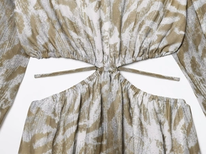 Detalle de vestido con estampado abstracto verde oliva, recorte en la cintura y cordón