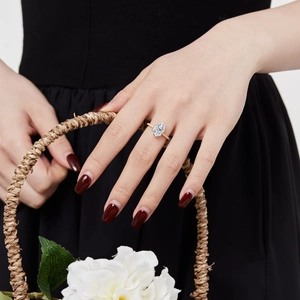 Detailed view of pear cut white zircon ring in gold finish on female model's hand