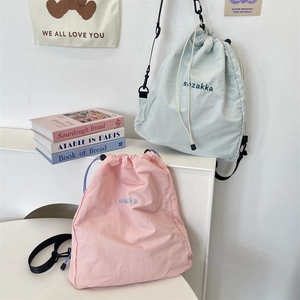 Detail of mint green and pale pink drawstring bags with waterproof nylon and adjustable straps