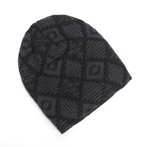 Dettaglio del berretto in maglia grigio scuro con trama geometrica a rombi in rilievo