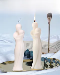 Detail minimalistischer cremefarbener Duftkerzen in Menschenform auf Goldtablett
