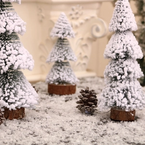 Artificial Christmas trees with fake snow and wooden bases for winter holiday decoration