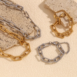Macro shot of 18K gold and silver paperclip chain necklaces on stone decor