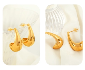 Detailed close-up of high-polish 18K gold plated teardrop earrings on white silk fabric