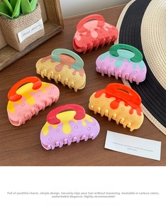 Detailed collection of six colorful acetate hair claws with fluid cream textures on wood