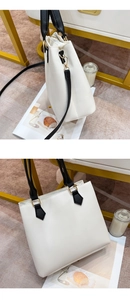 Detail showing white PU leather tote with black straps and elegant gold metal buckles