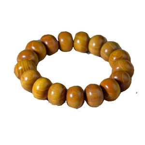 Bracelet minimaliste en bois de santal vert aux grains naturels sur fond blanc pur