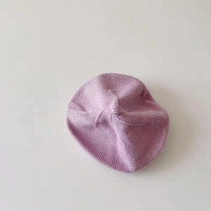 Top view of a purple knitted wool beret showing fine texture and round silhouette