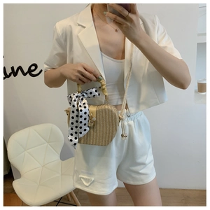 Straw apple bag detail with bamboo handle, scarf decoration and crossbody rope strap