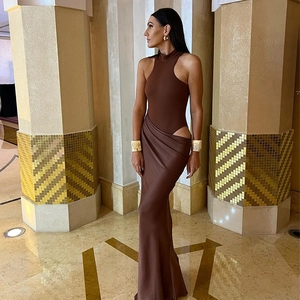 Detail of a brown sleeveless bodysuit with side cut-out and matching pleated maxi skirt