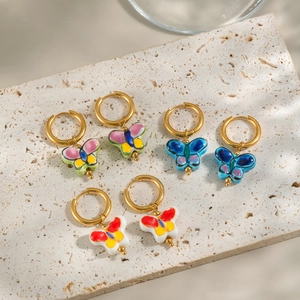 Three pairs of gold hoop earrings with colorful hand-painted ceramic butterfly pendants