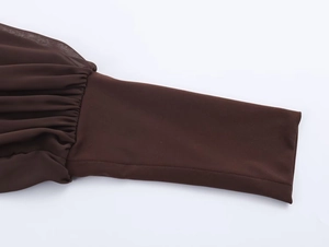 Dettaglio di maniche lunghe marrone scuro con chiffon arricciato e polsini elastici