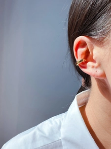 Polished 24k gold plated C-shaped ear cuff on model with clean white shirt background