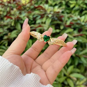 Detail of 18K gold plated leopard head bangle with emerald heart stone and pave zircons