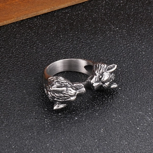 Macro shot of retro double wolf head ring in titanium steel on black leather background