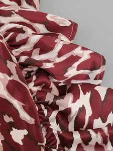 Close-up of satin abstract print fabric featuring ruffled edges and white stitching detail