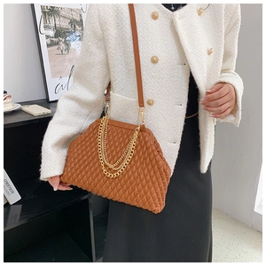 Detail of a brown quilted leather shoulder bag with gold chain and frame closure design