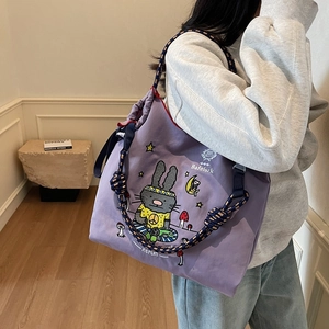 Large purple canvas tote bag with cartoon graffiti and braided navy blue rope handles